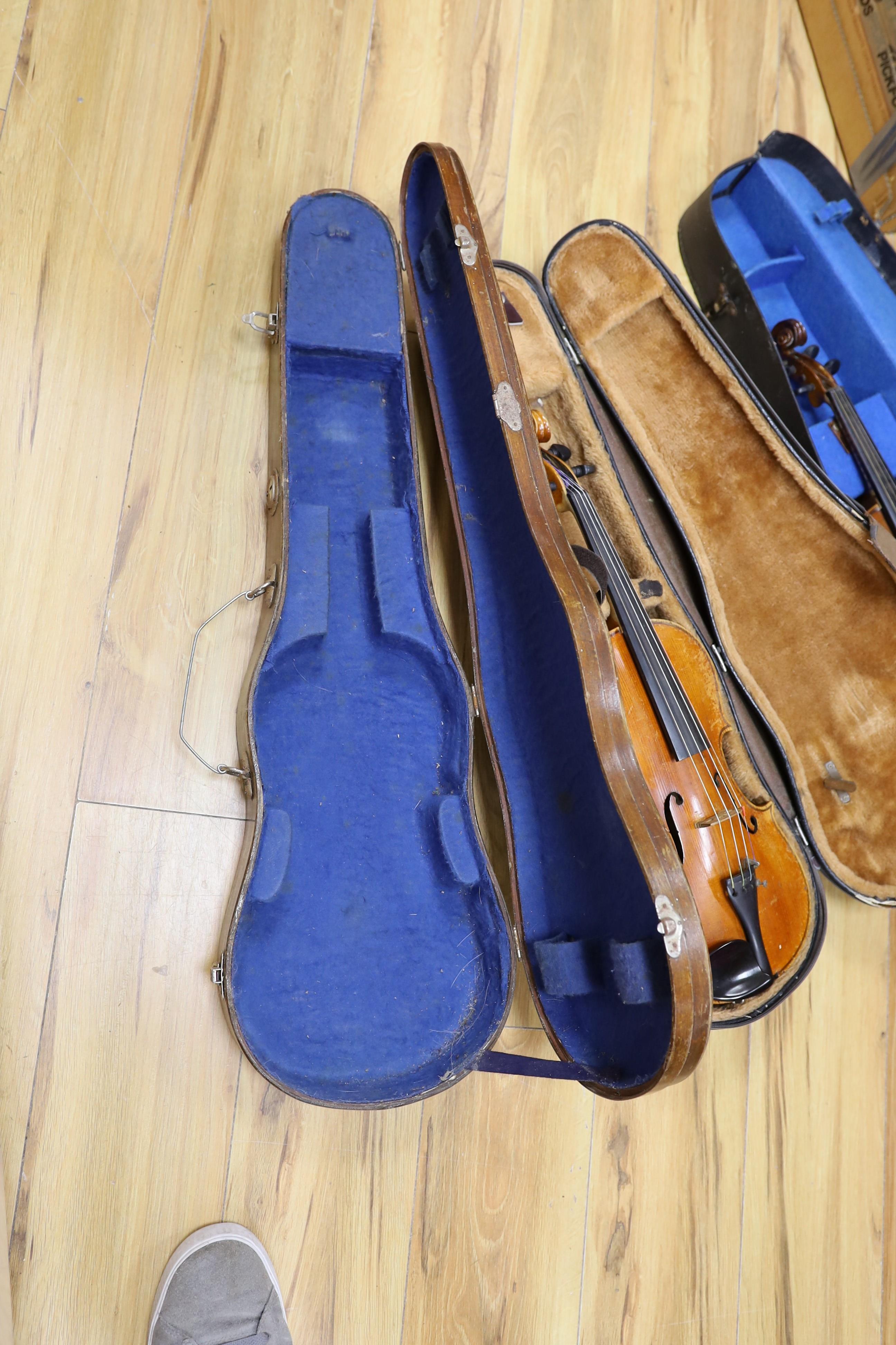 Two cased three quarter size violins, one labelled the London violin co Ltd, length of back 33.5 cm together with a wooden violin case